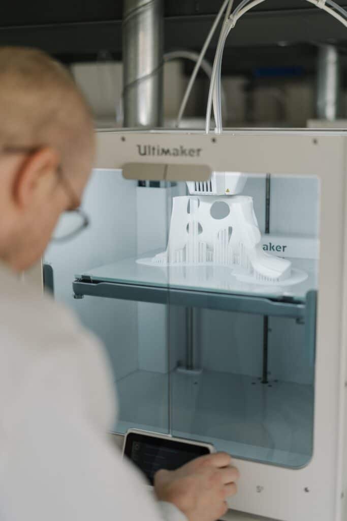 Man adjusting the settings on a white ultimaker 3d printer